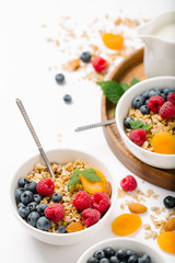 Homemade granola and healthy breakfast ingredients - milk, dried fruit and berries