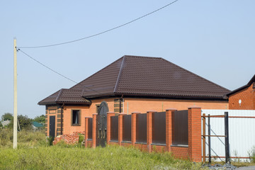 The house with plastic windows and a roof of corrugated sheet