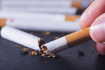 Broken cigarette on black background. Concept quit smoking.