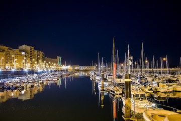 SANTANDER, SPAIN - February 20, 2017: Pier with many moored boats in the port at night