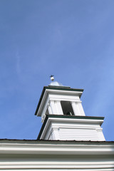 White cupola with green trim against a blue sky
