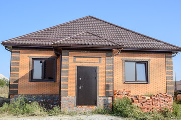 The house with plastic windows and a roof of corrugated sheet