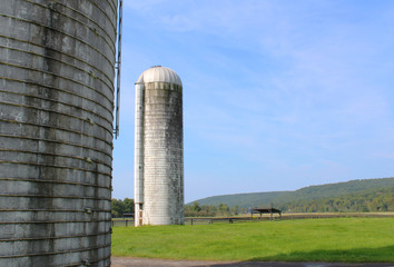 View of a silo in the distance with a portion of a silo to the left side
