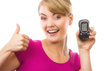 Woman holding glucose meter and showing thumbs up, checking and measuring sugar level concept