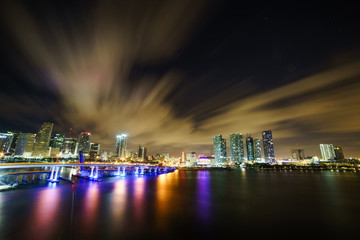 Fototapeta na wymiar Miami city skyline panorama at dusk with urban skyscrapers and bridge over sea with reflection