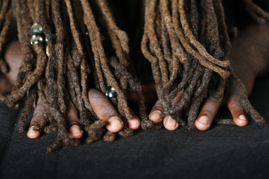 Conceptual image of Hands of African-American man and dreadlocks 