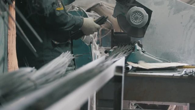 Manufacture of composite fiberglass reinforcement - worker cuts wires and counting production