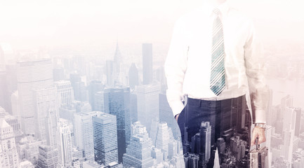 Business man standing on roof with city in the background