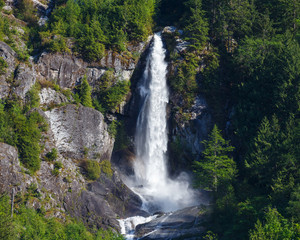 Majestic waterfall flowing down steep mountainous terrain within North Cascades National Park.