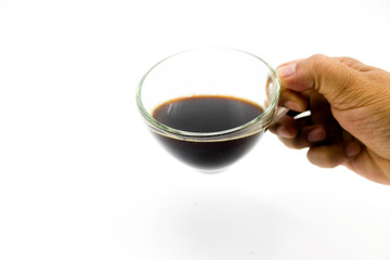 Black coffee in transparent glass being drunk with man hand