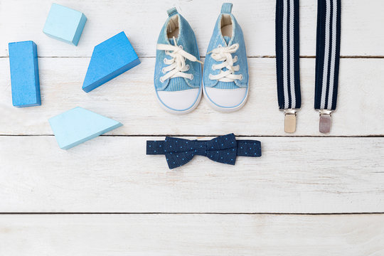Suspenders, a bow tie and blue shoes for a boy. view from above