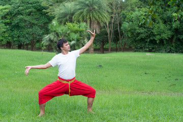 Asian young boy Thai dance. Classical Dance in white shirt red loincloth, Demonstrate dance in the garden.