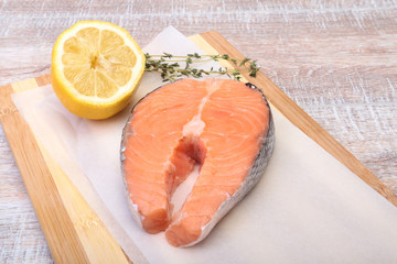 fresh raw salmon with spices and lemon on wooden cutting board. ready for cookin