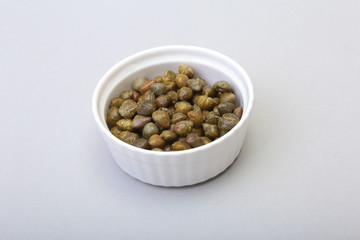 bowl with fresh capers isolated on white background.