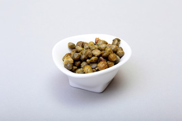 bowl with fresh capers isolated on white background.