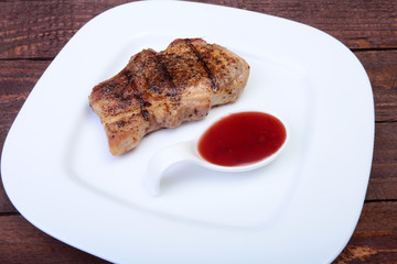 grilled pork chop with Cranberry sauce on plate on wooden board
