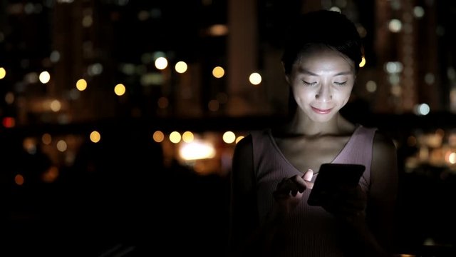 Woman using smart phone at night