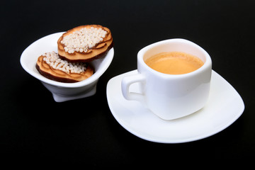 Classic espresso in white cup with homemade cake on black background. Selective focus.
