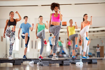 Group of people exercising on stepper - obrazy, fototapety, plakaty