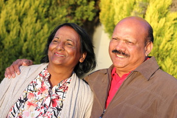 Relaxed, close-up portrait of happily married, elderly Asian couple in natural, afternoon light