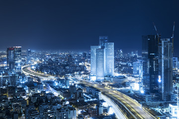 Fototapeta na wymiar Tel Aviv Skyline At Night, Skyscraper and Ayalon Freeway - Toned In Blue