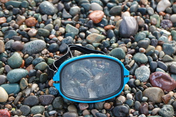 mask for scuba diving on a pebble beach