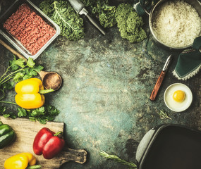 Minced meat with rice, kale and vegetables ingredients on kitchen table background, top view, frame