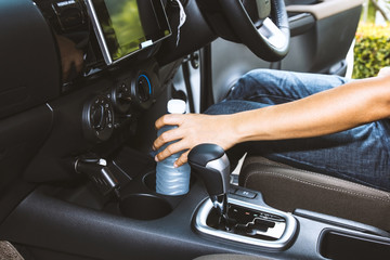 Woman hand holding drinking water bottle on cup holders