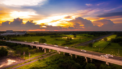 Fototapeta na wymiar Aerial Photo Countryside Car Running on Road Bridge Over Railway and Golden Hour Sky Beautiful Landscape Drone View