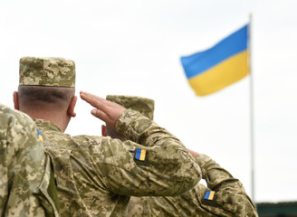 Ukrainian soldiers giving salute. Flag of Ukraine