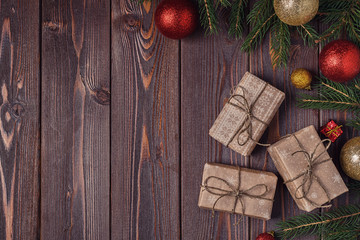 Christmas gift boxes and fir tree  on wooden background.