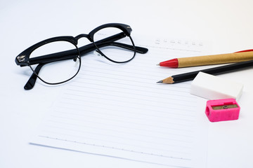 Black glasses, white paper, pencil, pen, pink sharpener and eraser (rubber) for write your note - concept relax.
