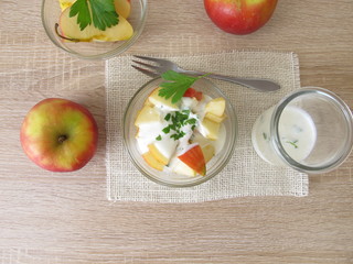Obstsalat mit Äpfeln und Sellerieblättern in Joghurt mit Apfelessig