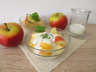 Obstsalat mit Äpfeln und Sellerieblättern in Joghurt mit Apfelessig