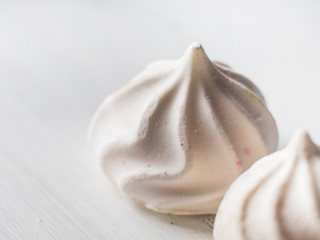 White meringue macro on wooden board. Texture