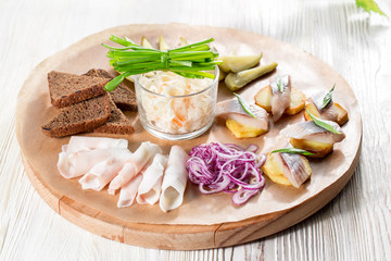 Sandwiches of potato slices with herring, red onions, herbs and rye bread. bacon slices and pickles