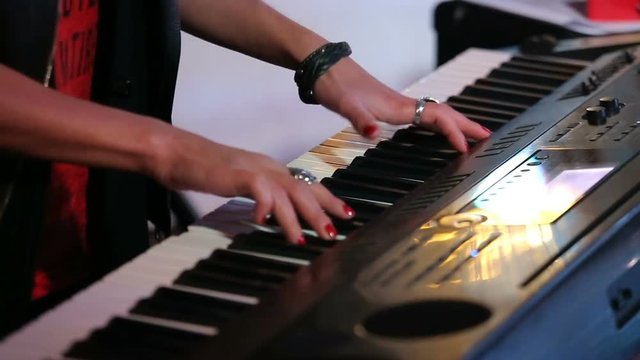 Womans hands playing keyboard on concert.