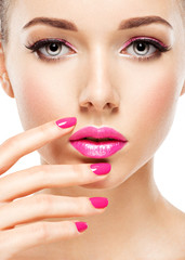 eautiful woman face with pink makeup of eyes and nails.