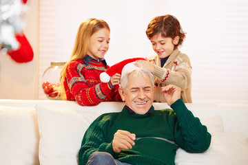 Kinder spielen mit Großvater an Weihnachten