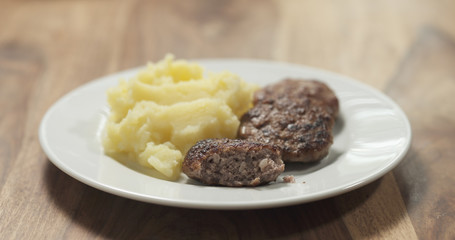 mashed potatoes with cutlets on white plate