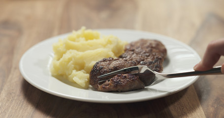 mashed potatoes with cutlets on white plate