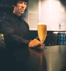 ビールを差し出すバーテンダー