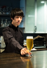ビールを差し出すバーテンダー