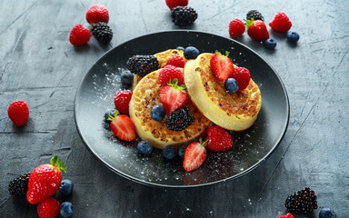 British Crumpets breakfast with blueberries, strawberries, blackberries, raspberries drizzled with...