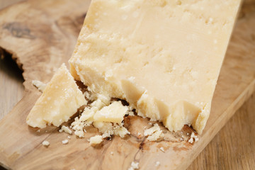 pieces of hard parmesan cheese on olive board