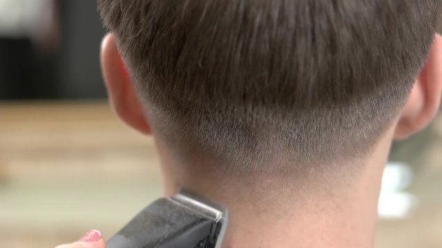 Head, hair clipper and comb. Guy getting haircut, close up.