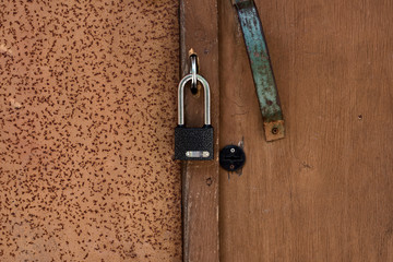 A new metal padlock on an old wooden door, close