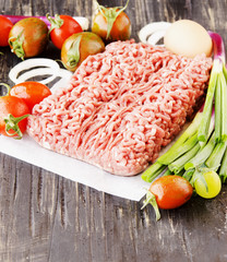 raw minced meat, vegetables with salt and spices, selective focus