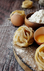 Uncooked pasta with flour on the table, selective focus