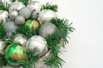 A festive Christmas arrangement artificial branches, glass balls in the basket.